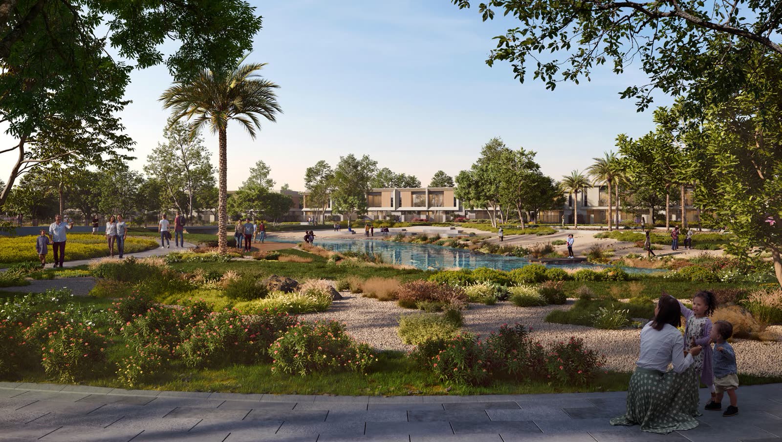 Landscaped park with a planted stream and families walking at The Valley